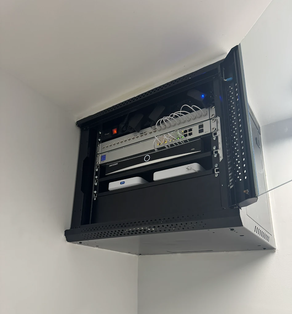 Bastidor de parede com switch, gravador de vídeo e dois pontos de acesso Wi-Fi.